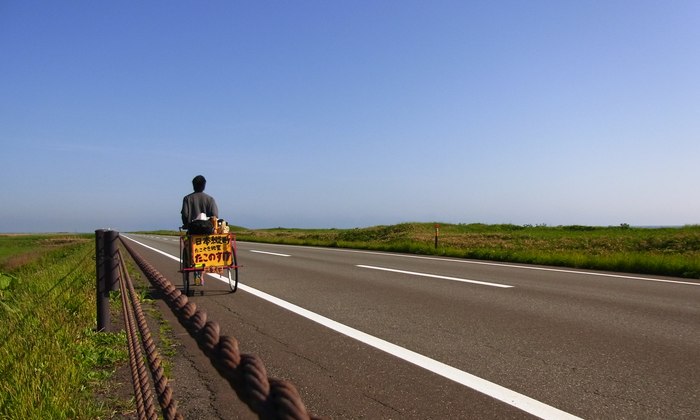 リヤカーでたこ焼きを引きながら一本道を進む森田松之助
